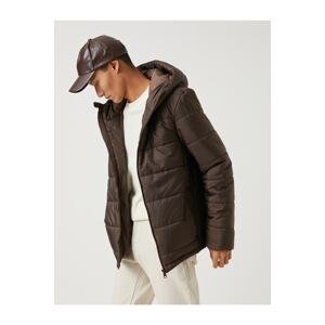 Péřová bunda Koton Basic s kapucí a kapsou na detailním zipem, voděodolná.